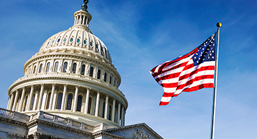 A view of the US Capital building and the American flag.